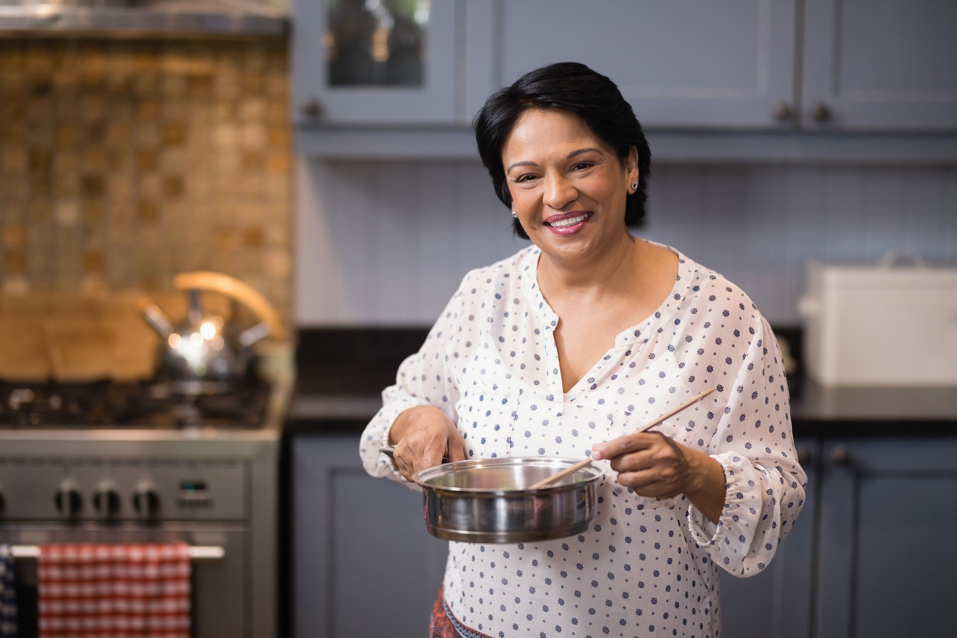 Portrait of woman preparing food in kitchen
